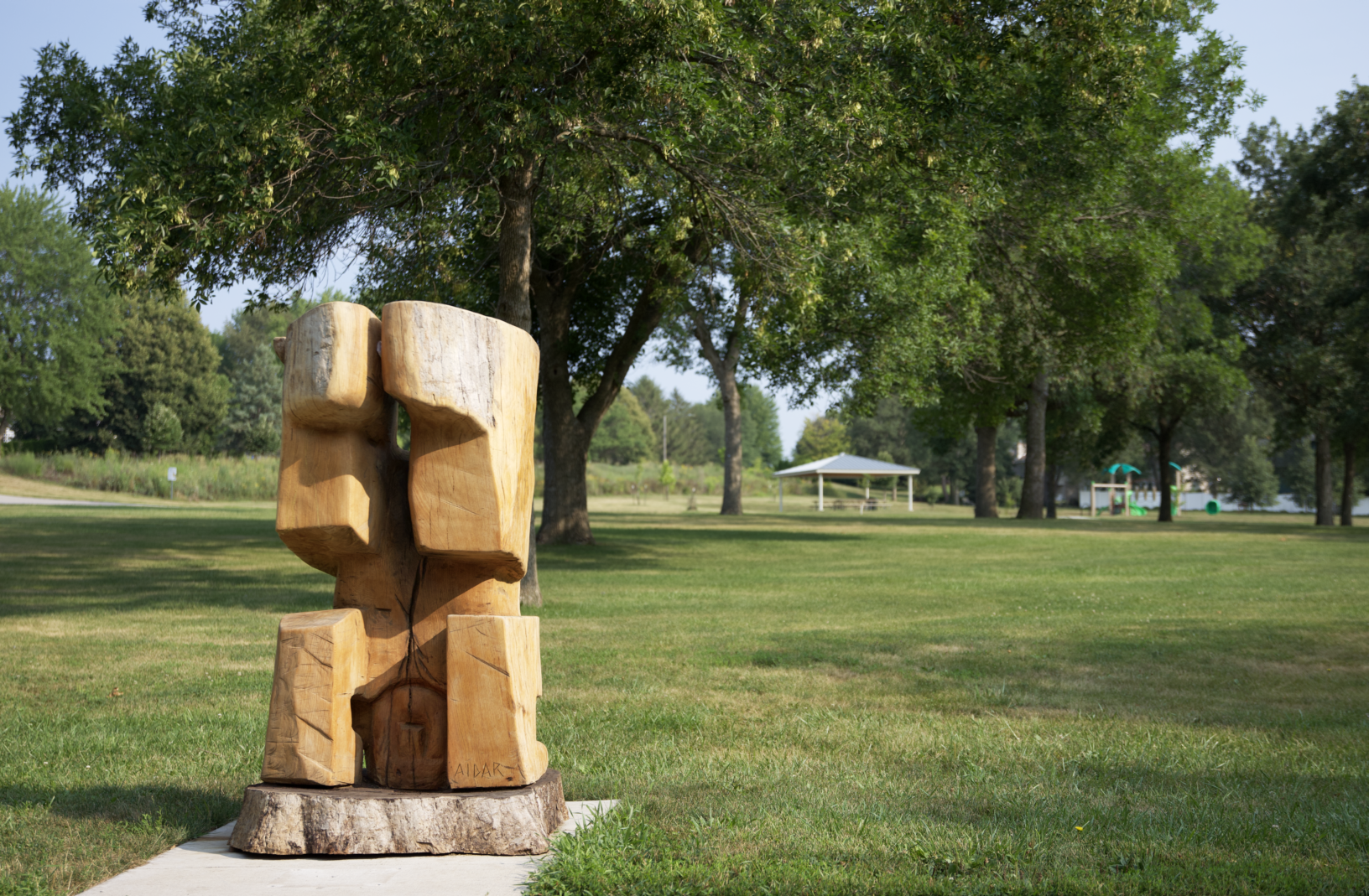 Wood sculpture is shown in park. 